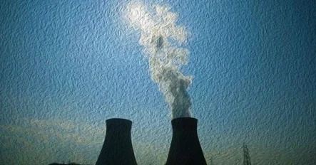 Two large cooling towers emit white steam into a blue sky, with the sun partially visible above them; a power line is seen in the background.