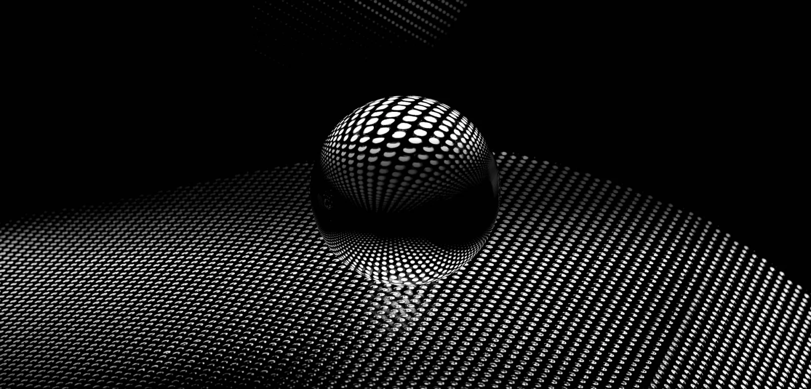 A reflective sphere sits on a surface covered with a grid of white dots on a black background, creating an abstract, patterned visual effect.