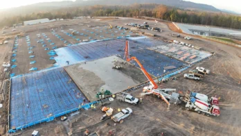 A construction site with a crane and cars.