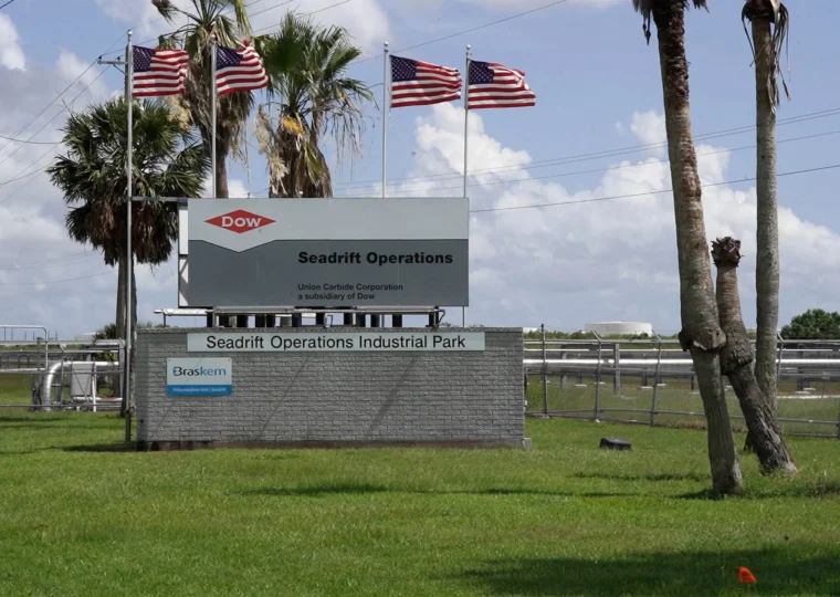 Signage for the Dow Seadrift Operations industrial park, featuring the Dow and Braskem logos and American flags flying overhead.